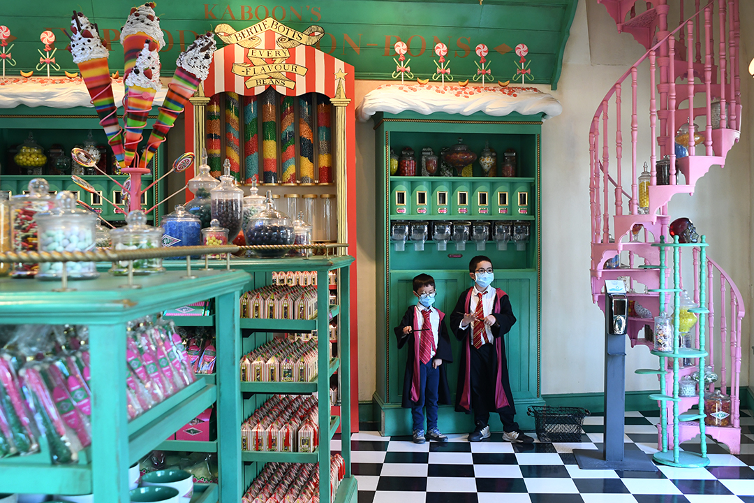 Boys in Harry Potter robes stop for treats at Honeydukes sweet shop at Universal Studios Hollywood's Wizard World of Harry Potter top tips for families