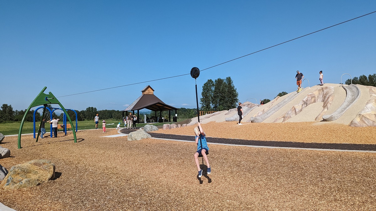 A girl rides the zip line at the new playground at Kent’s Van Doren’s Landing Park near Seattle