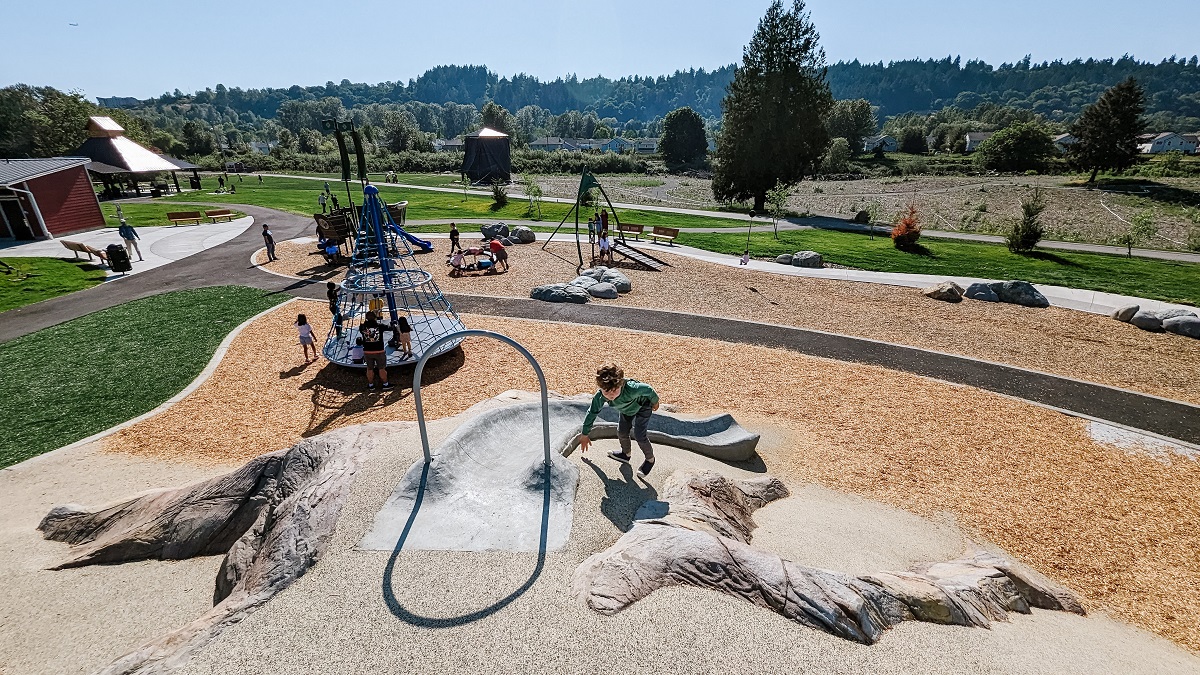 Looking over the updated playground features at Van Doren’s Landing park playground including a mini Mount Rainier, cone spinner, pirate ship play structure and swings