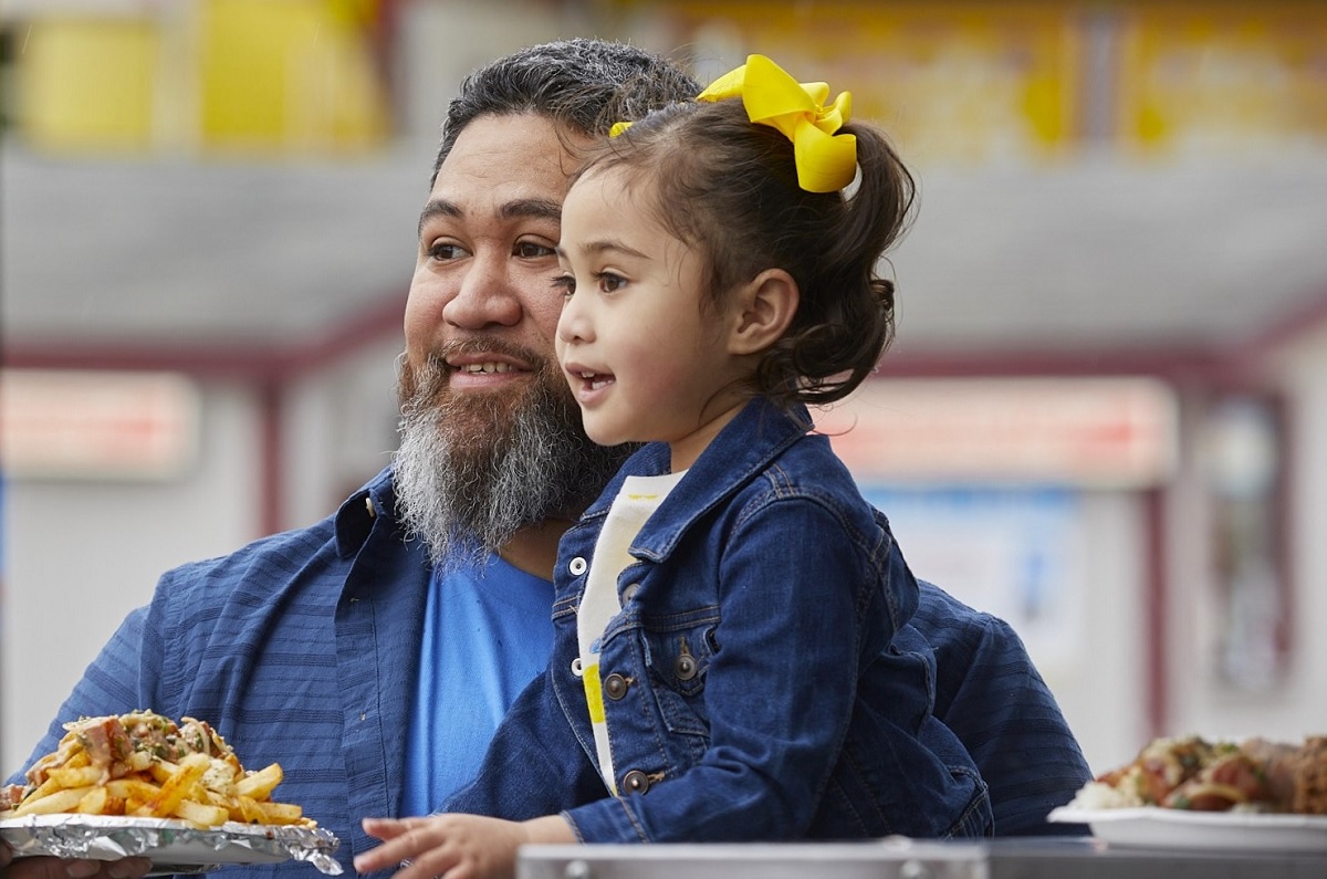 At the Washington State Fair, a dad and young daughter get ready to eat fair food