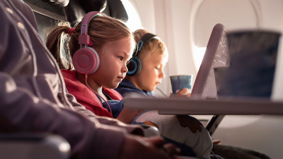two little kids watching movies on a plane