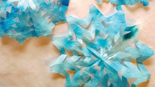 "snowflakes cut from coffee filters with blue dye added"