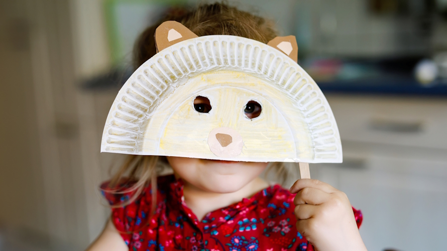 Child holding up an animal mask