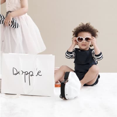 "Baby wearing sunglasses next to a Dropple box"