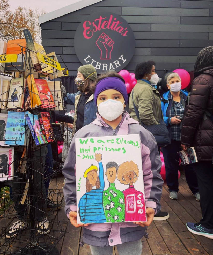 "Young girl wearing a face mask holding a book"