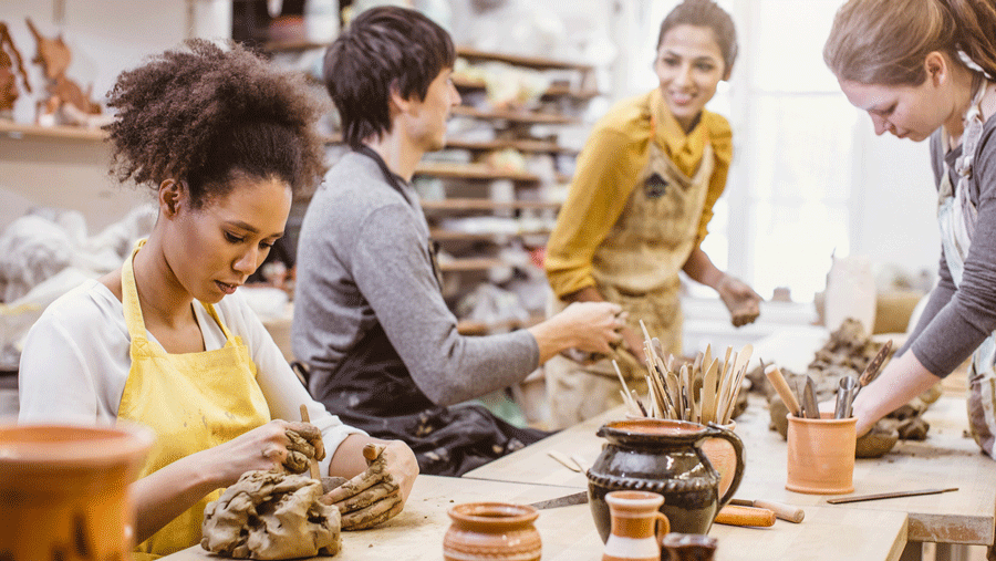 a woman molds pottery as a fall craft for adults to make