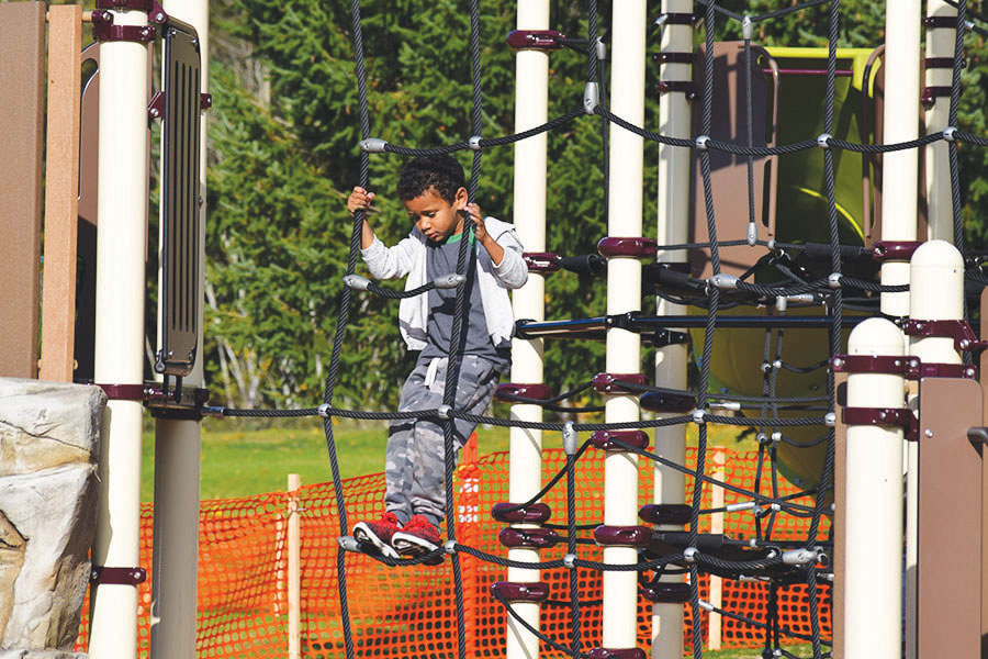 "Young boy playing on a playground at Gateway park"