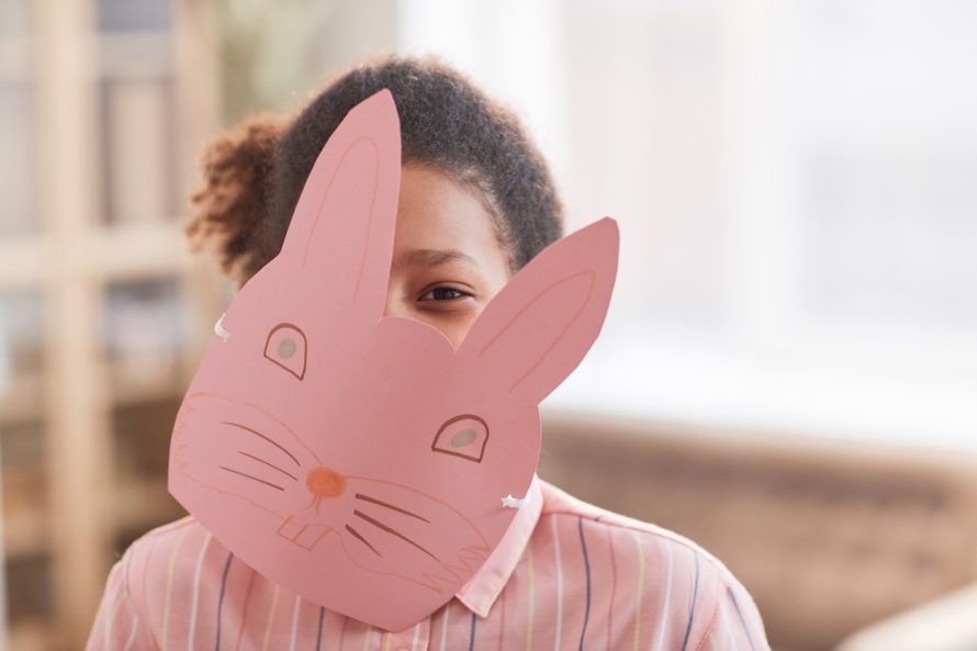 "Young girl wearing a paper rabbit mask"