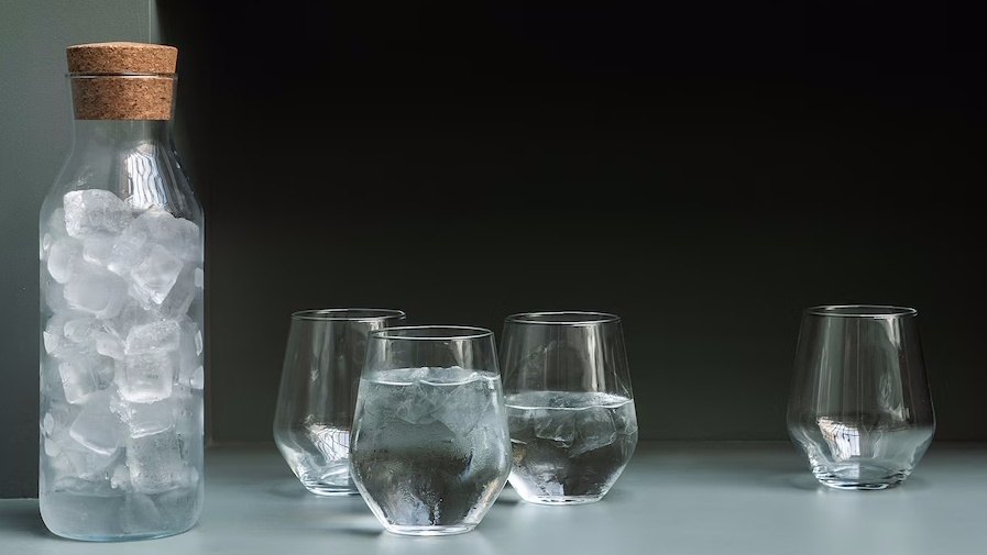 Water pitcher filled with ice sitting next to water glasses hosting essentials from ikea
