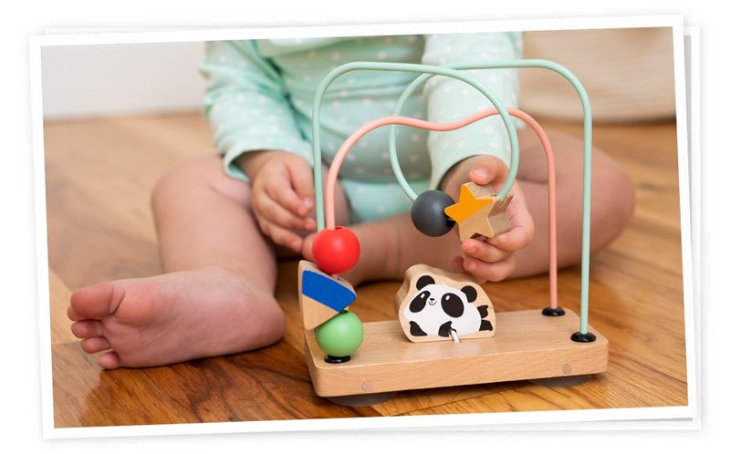 "Baby playing with wooden toy"