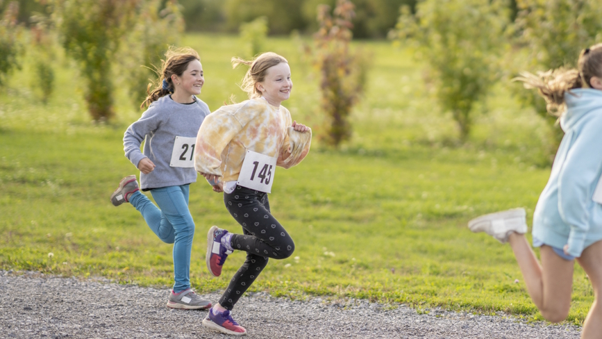 "Two girls running in a race benefits of running for kids"