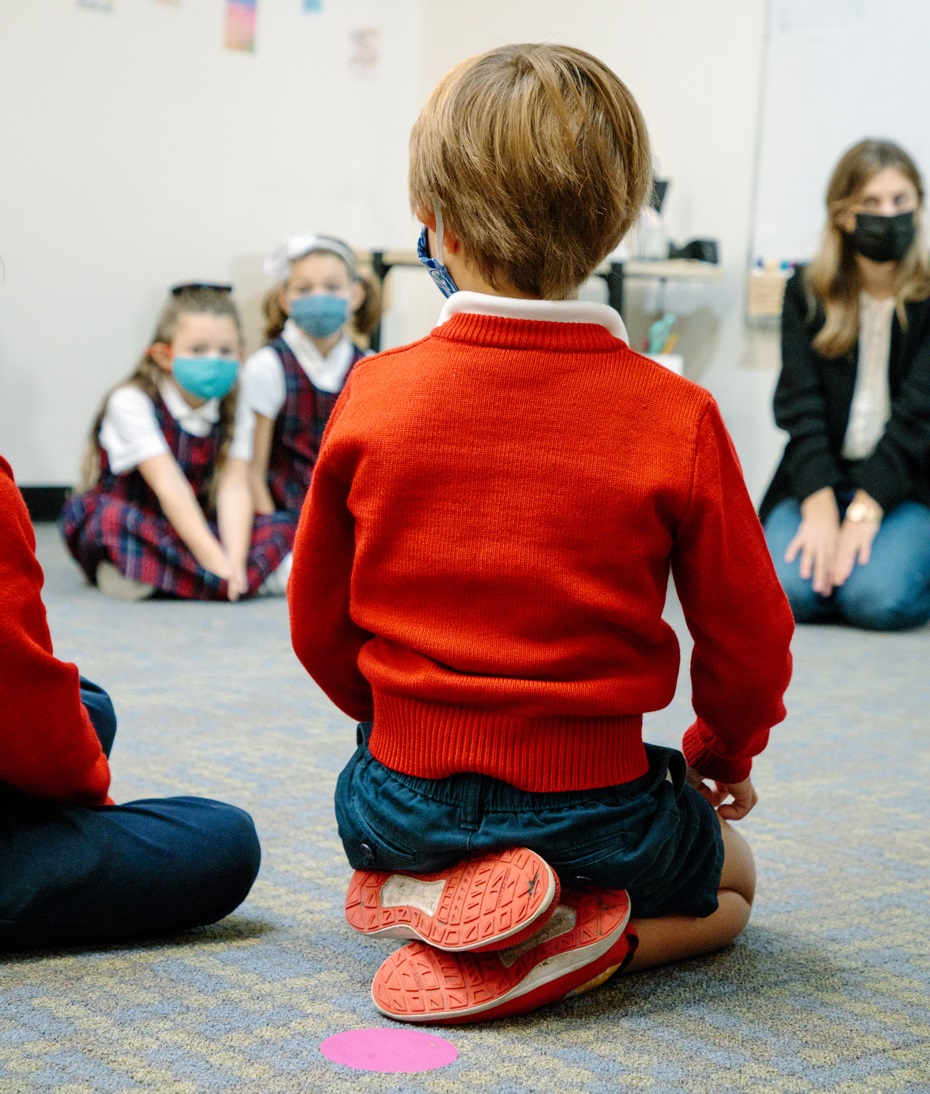 A young student sits in a circle with his classmates at Seattle's Epiphany School