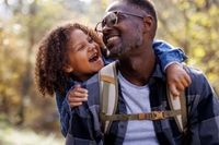 Dad with child outdoors on hike in warm embrace