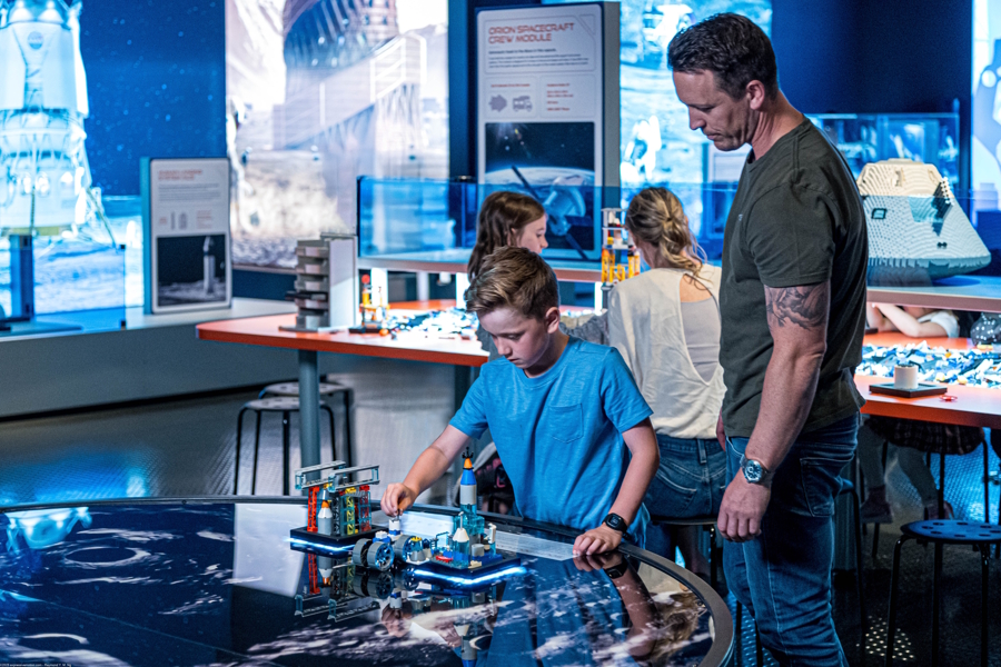 dad and kids with Lego bricks at Artemis Adventure exhibit