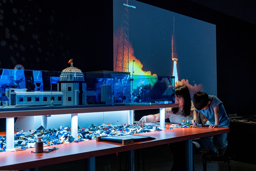 Lego building and kid and mom using Lego bricks at the Artemis Adventure xhibit