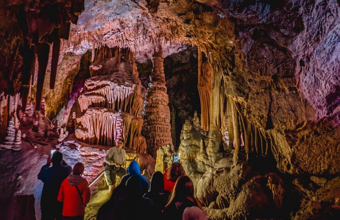 Hikers and visitors inside lewis and clark caverns best stops on a family camper van road trip western national parks