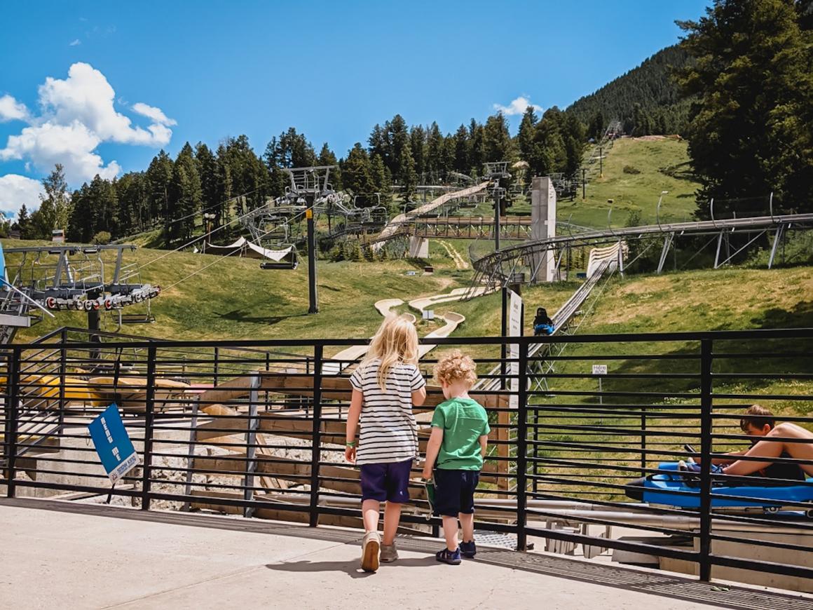 Kids standing at base of Cowboy Coaster attraction fun roadside stop for families during road trip western U.S. #vanlife