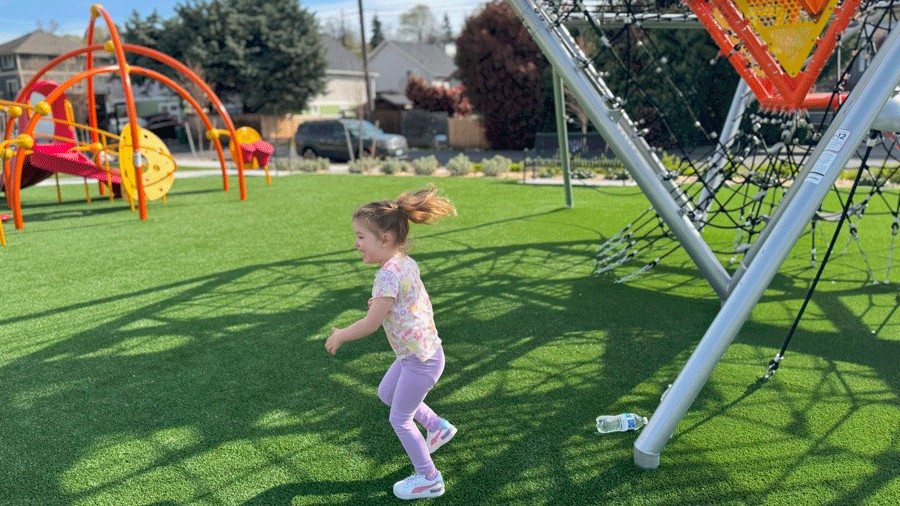 girl running on the playground at Cheryl Chow Park in Seattle