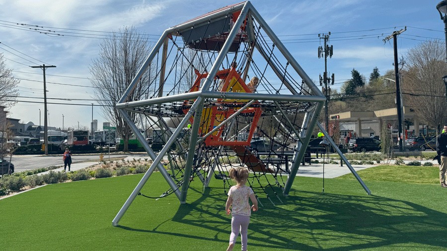 young girl running to giant rope ladder climber at Cheryl Chow Park's playground