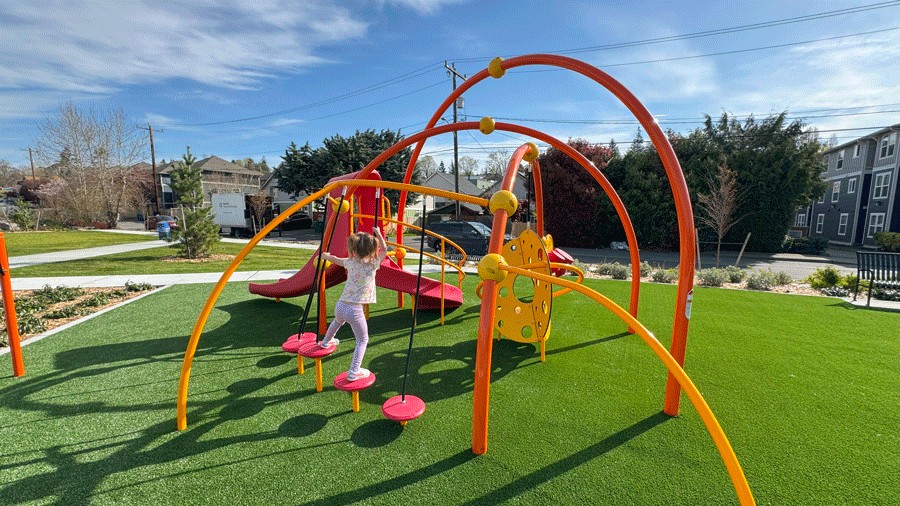 young girl balancing on stepping stones on playground structure for ages 2–5 at Cheryl Chow Park 