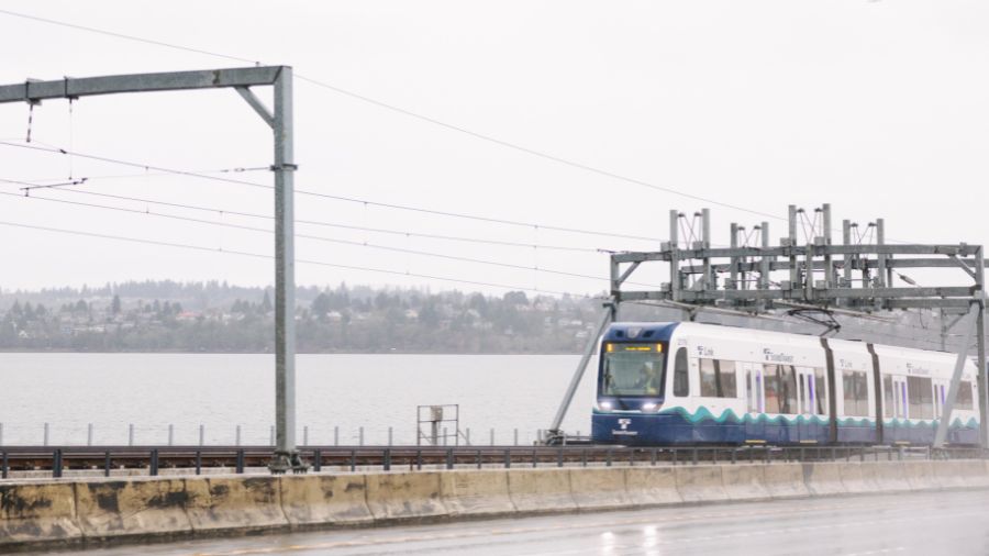Image of light rail going over bridge cloudy sky