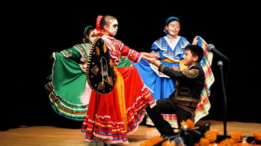 A boy and girl dressed in costume dance at the Kirkland Día de los Muertos celebration