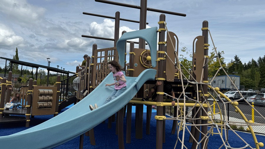girl sliding down the slide at Doris Heritage's fishing playground