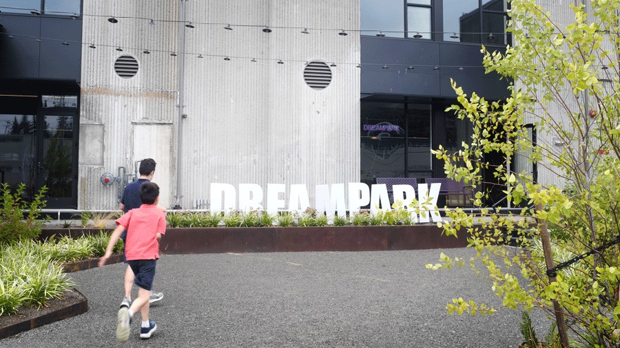 kids running to the entrance of DreamPark Seattle, a new mixed-reality theme park