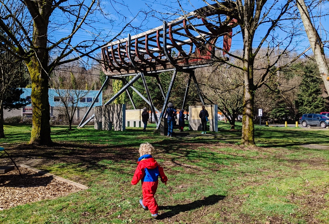 Small boy in red rainsuit outside the Duwamish Longhouse Museum 