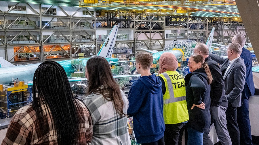 people look at airplanes on the floor of the Boeing facility in Everett during the factory tour