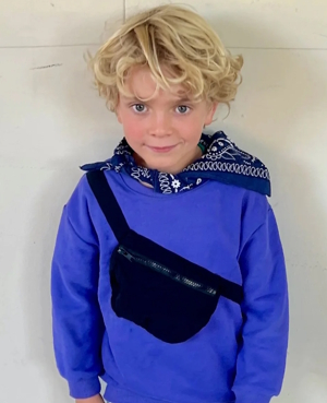 boy wearing a blue sweater with a belt bag across the front
