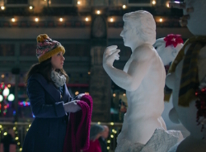 Woman holding a scarf about to put it on a snowman