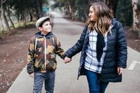 Mom with son on walk outside, holding hands