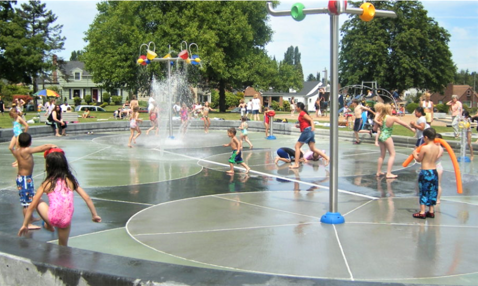 Kids and families playing at Jefferson Park sprayground in Tacoma