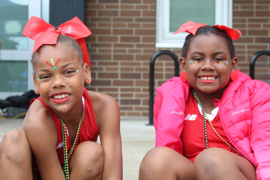 Two young African American girls are dressed in dance uniforms to perform at a Juneteenth celebration.