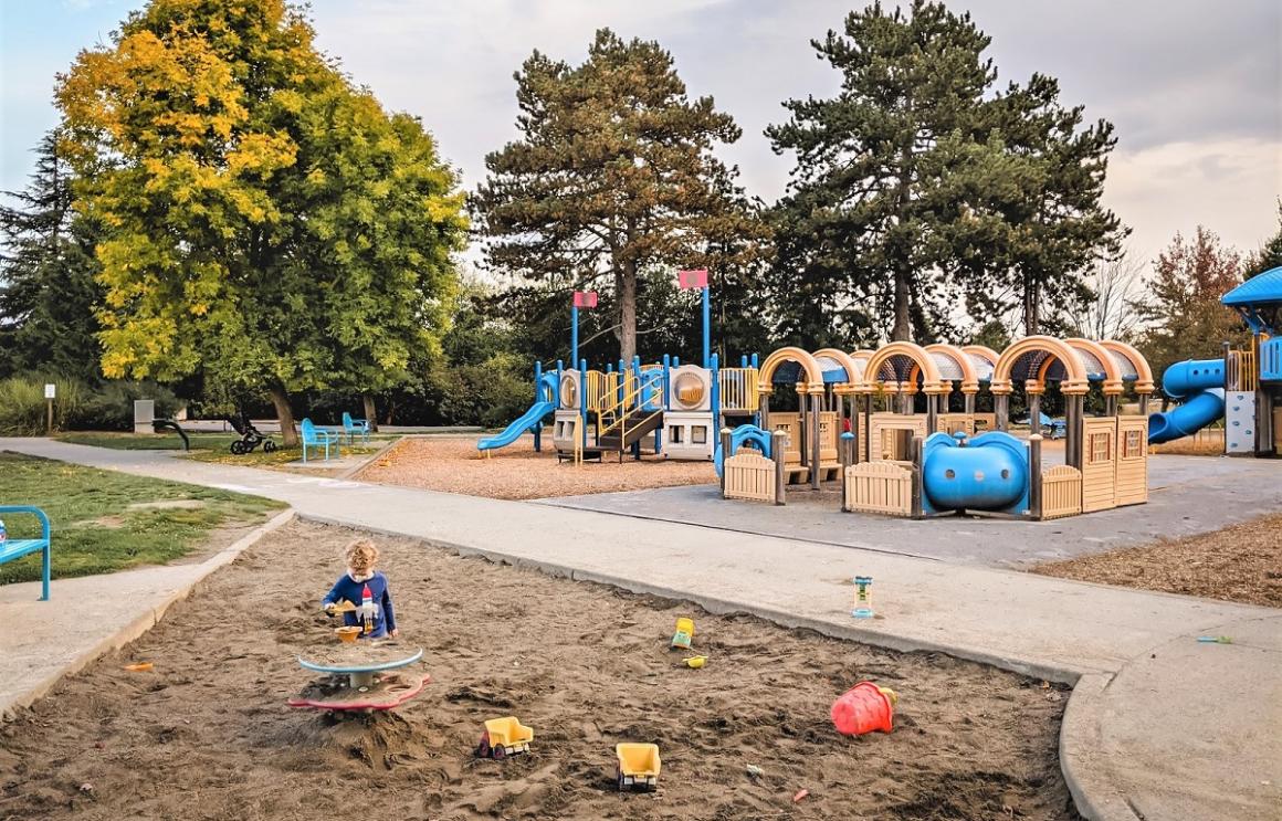 Boy playing in sand pit at Junior League Air Land and Sea playground at Seattle's Magnuson Park