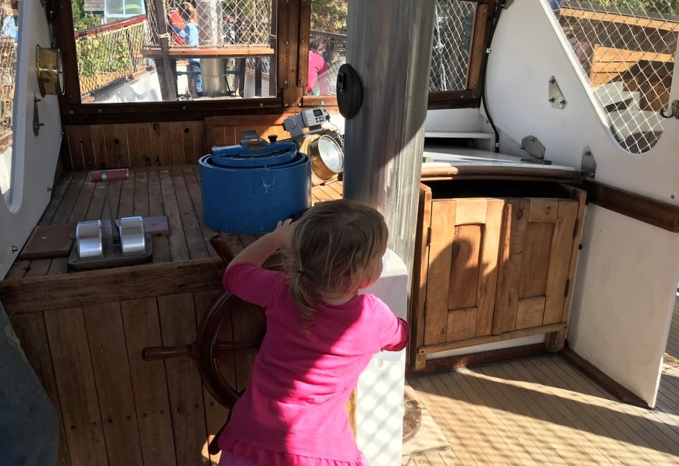 Girl-at-helm-vintage-schooner-Megan-D-Hands-On-Childrens-Museum-Olympia