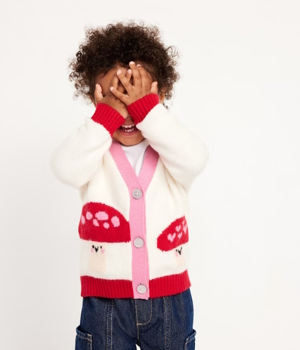 Child wearing a sweater with mushrooms on it