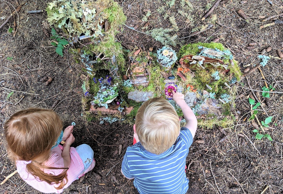 Magical fairy house found along the Pine Lake Fairy House Trail in Pine Lake Park in Sammamish two kids inspecting it