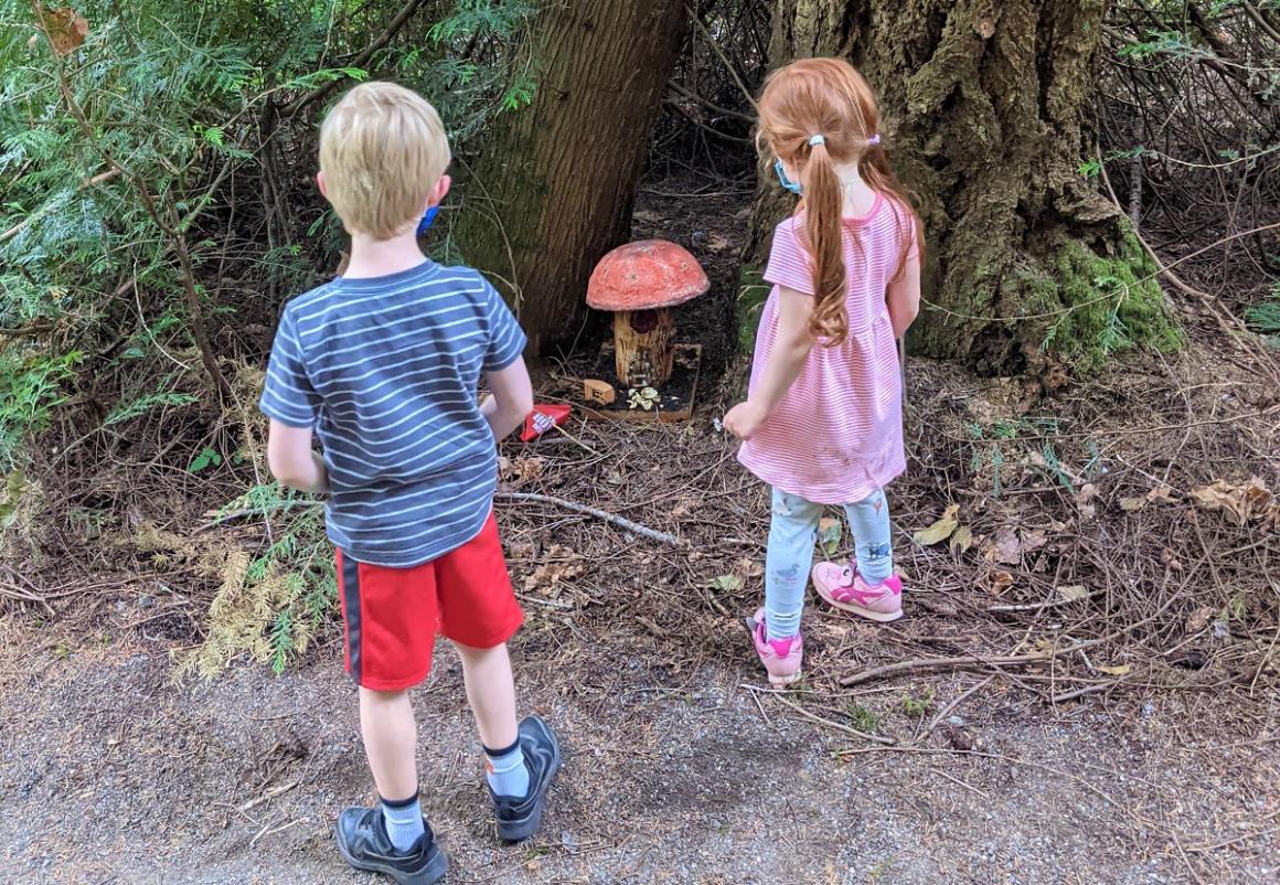 Pine Lake Fairy House Trail toadstool house with two young kids looking on fun Eastside activities for kids June 2021