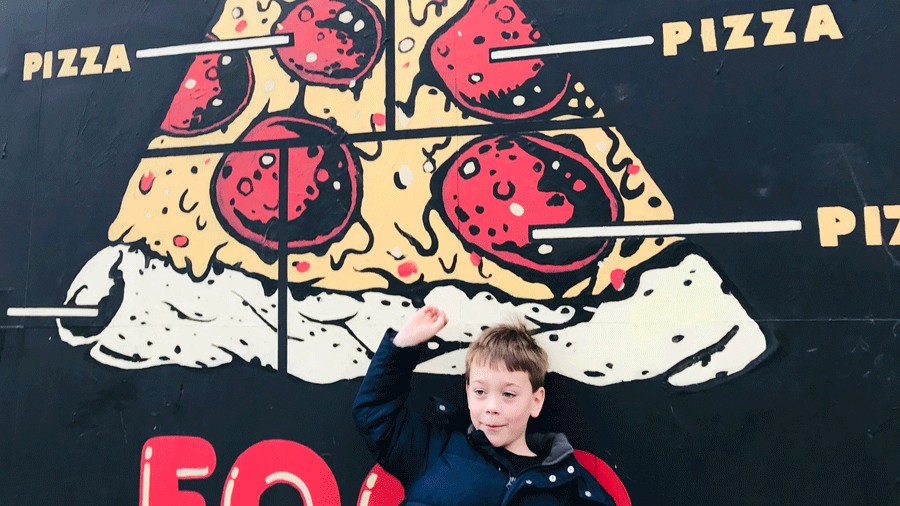 young child pointing at a pizza mural in downtown Portland