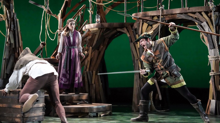 Robin Hood holding a sword onstage during a lively performance