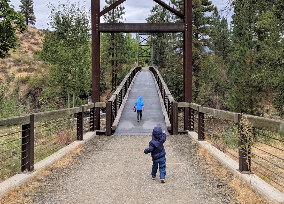Kids crossing the Sa Teekh Wa Trail suspension bridge in Winthrop Washington fall family getway Methow Valley
