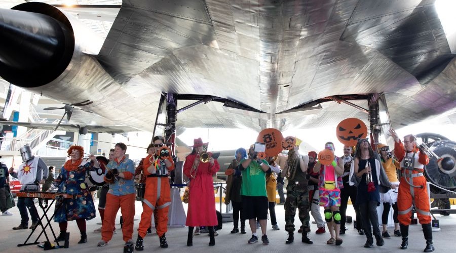 A brass band performs under an aircraft at Museum of Fright.