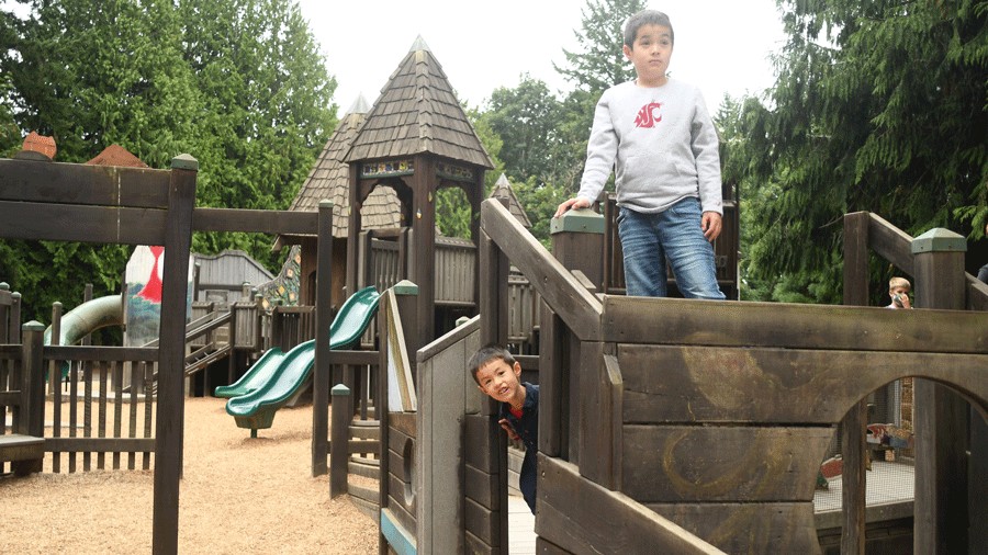 kids playing on a playground outside The Lodge at St. Edward Park after family brunch