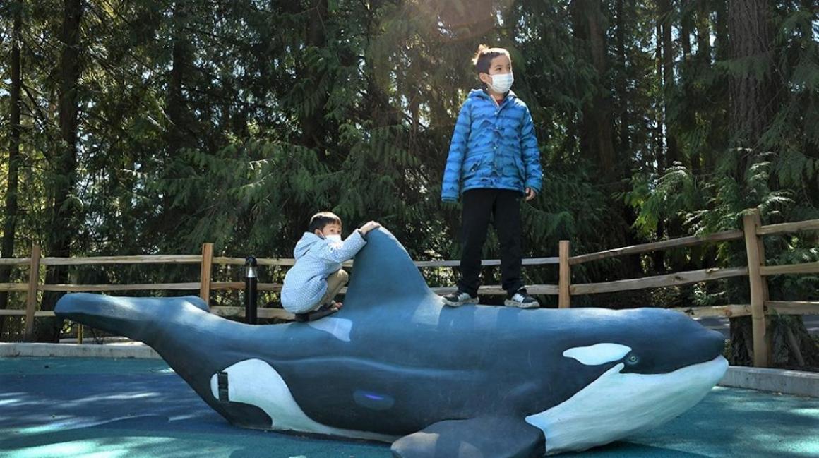 Suquamish Shores Natural Play Area kids standing on orca statue; credit JiaYing Grygiel