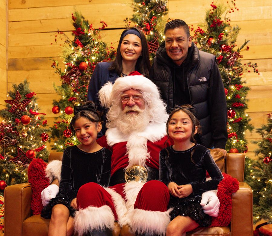 Two children and their parents pose for a photo with Santa at Village at Totem Lake near Seattle