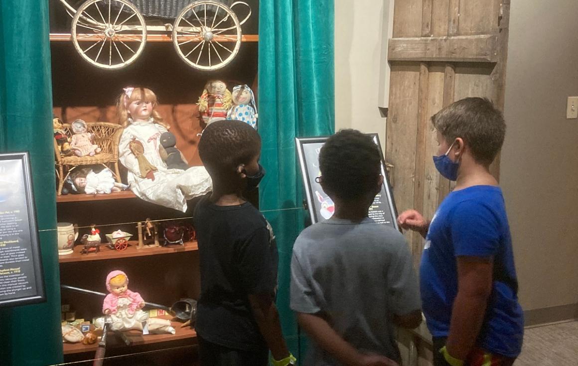 Kids visiting White River Valley Musuem's Closets of Curiosity exhibit look at old creepy dolls