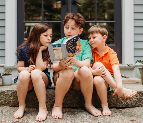 PJ LIbrary: Kids reading a book on their front porch