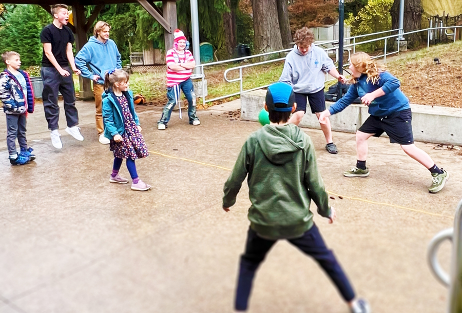 kids playing basketball outside at a recess at school